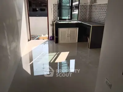 Bright kitchen with glossy tiled floor and modern cabinetry