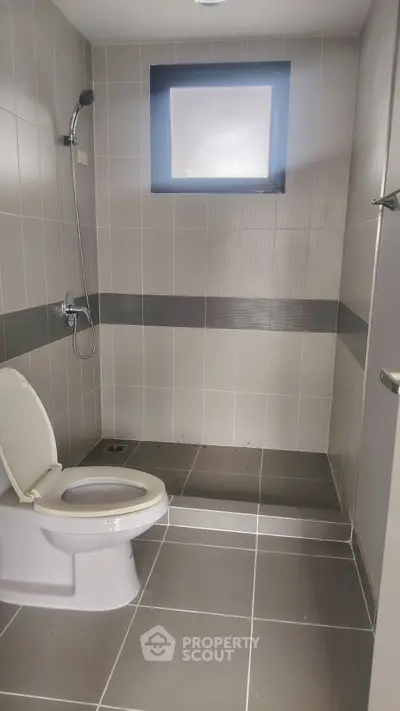 Modern bathroom with sleek gray tiles and walk-in shower design
