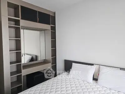 Modern bedroom with built-in shelving and cozy bed in stylish apartment.