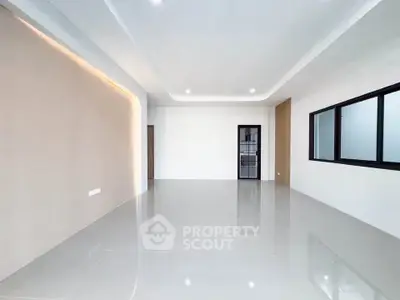 Spacious modern living room with sleek design and large windows.