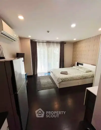 Modern bedroom with balcony access and stylish decor in a cozy apartment.
