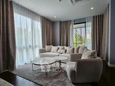 Luxurious living room with elegant decor and large windows offering natural light.