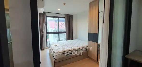 Cozy bedroom with large window and modern furnishings in a stylish apartment.