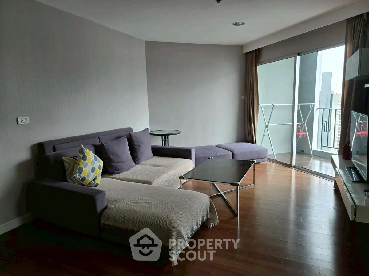 Spacious living room with modern furniture and balcony access