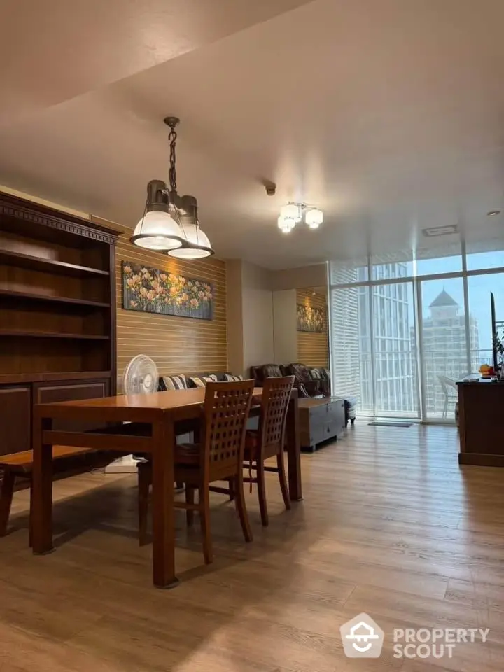 Spacious living room with elegant wooden furniture and city view balcony