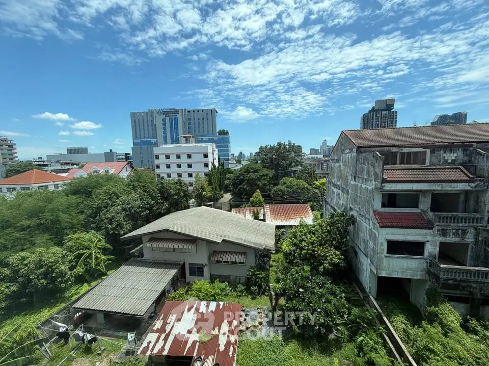 Stunning cityscape view with lush greenery and urban buildings under a clear blue sky.