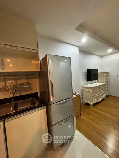 Cozy apartment kitchen with modern fridge and stylish living area
