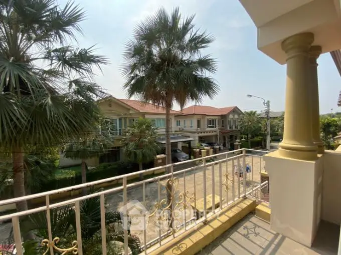 Charming balcony view of suburban homes with lush greenery and palm trees.