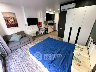 Modern studio apartment with cozy living area and compact kitchen, featuring stylish decor and ample natural light.