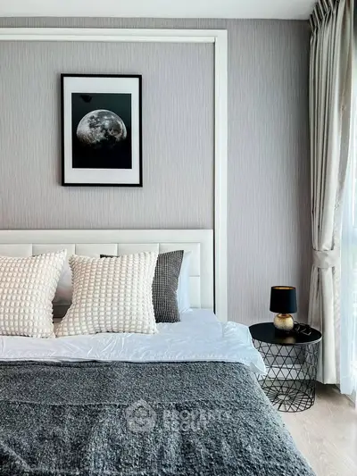 Modern bedroom with stylish decor and natural light, featuring a cozy bed and elegant side table.