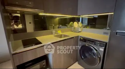 Modern kitchen with sleek appliances and integrated washing machine
