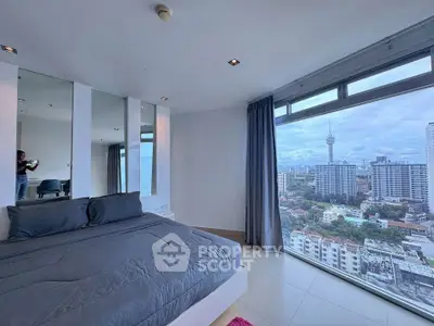 Luxurious bedroom with stunning city view and modern decor in high-rise apartment.