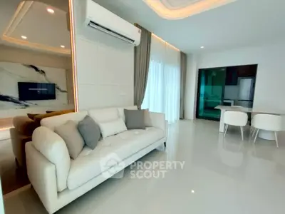 Modern living room with elegant sofa and dining area, featuring stylish decor and ambient lighting.