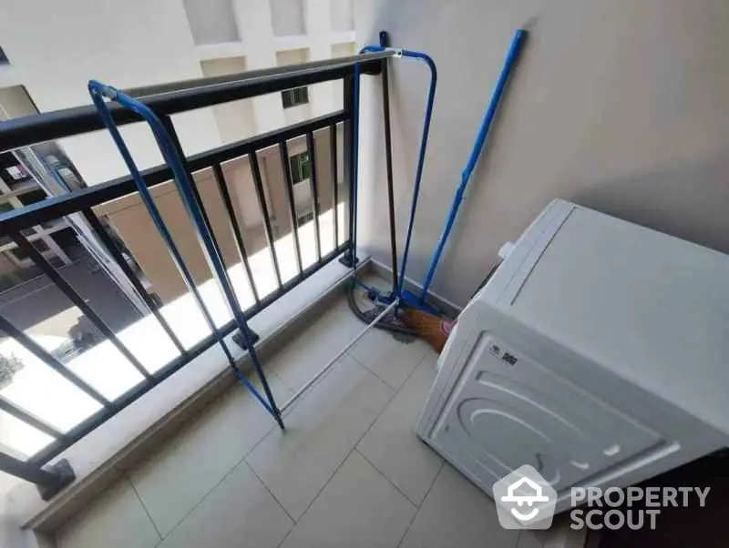 Compact balcony with washing machine and drying rack in modern apartment