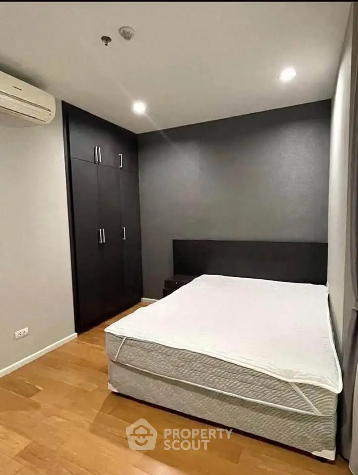 Modern bedroom with sleek design, featuring a comfortable bed and built-in wardrobe, perfect for urban living.