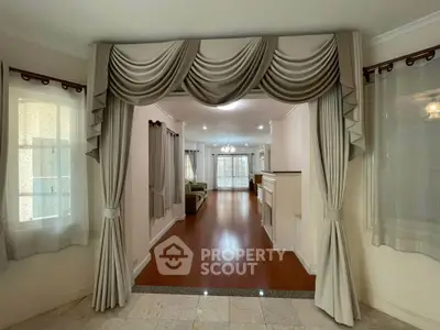 Elegant living room with draped curtains and polished wooden floors