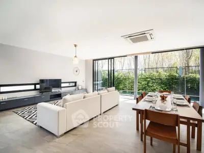 Spacious modern living room with large windows and garden view, perfect for family gatherings.