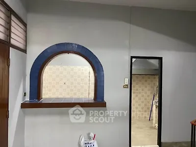 Charming interior with unique arched window and tiled accents, perfect for creative renovation.