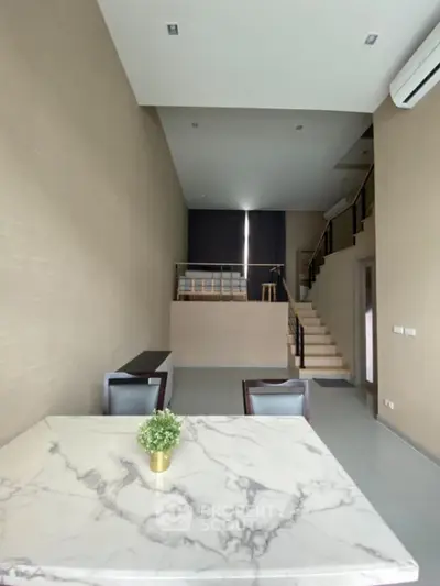 Modern duplex interior with marble dining table and stylish staircase