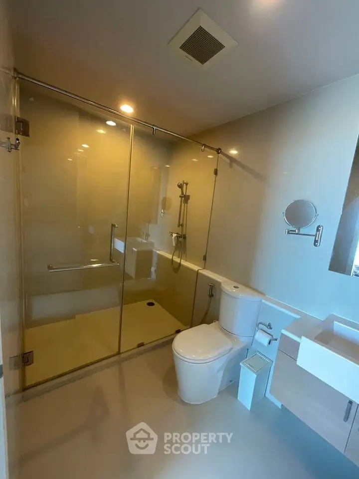 Modern bathroom with glass shower enclosure and sleek fixtures