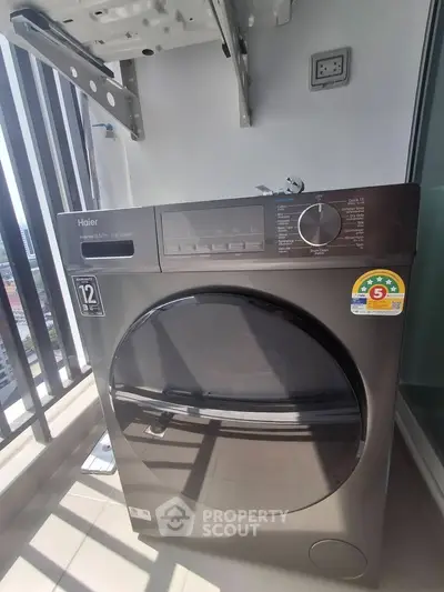 Modern Haier washing machine on a balcony with city view, perfect for urban living convenience.