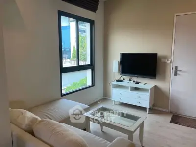 Cozy living room with modern decor and natural light, perfect for relaxation.