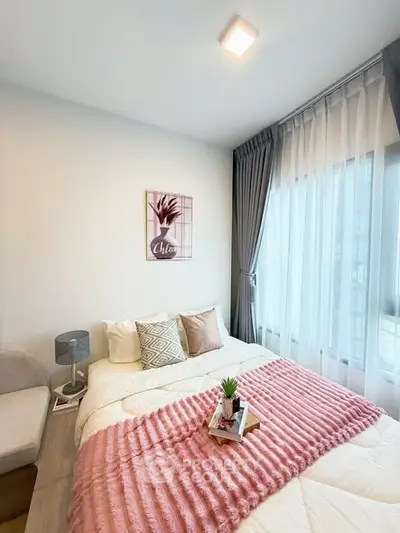 Cozy bedroom with stylish decor and large window for natural light.