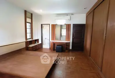 Spacious bedroom with wooden flooring and built-in wardrobe