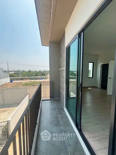 Modern balcony with sliding glass doors and scenic view of greenery, perfect for relaxation and outdoor enjoyment.