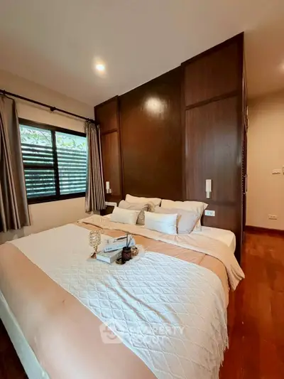 Cozy bedroom with elegant wooden accents and soft lighting, perfect for relaxation and comfort.