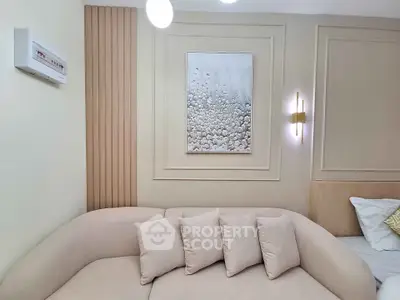 Elegant living room with modern beige sofa and stylish wall art, perfect for cozy relaxation.