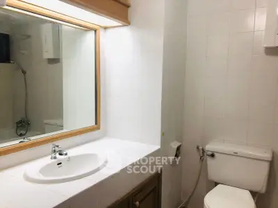 Modern bathroom with white tiles and sleek fixtures in a real estate property.