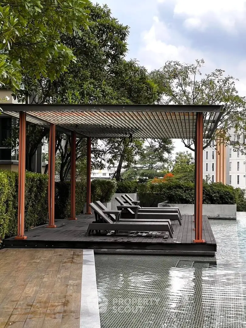 Luxurious poolside cabana with modern lounge chairs and lush greenery, perfect for relaxation and leisure.