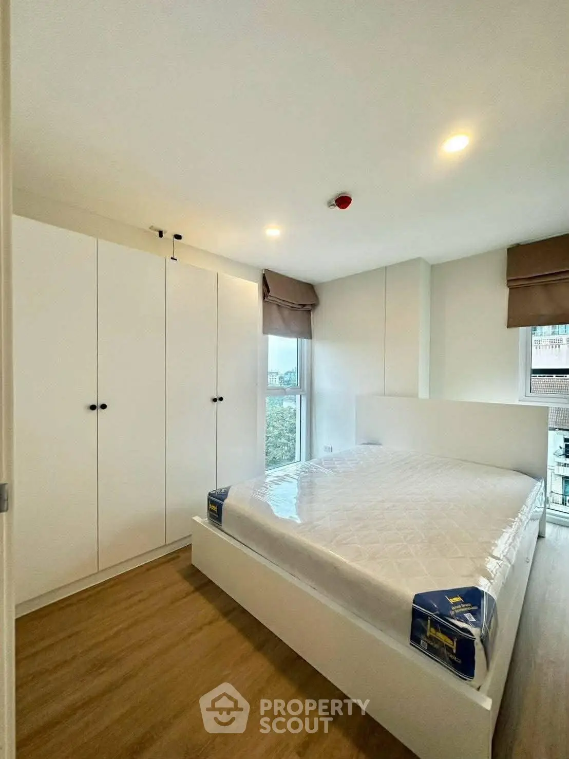 Modern bedroom with large window and sleek white furniture