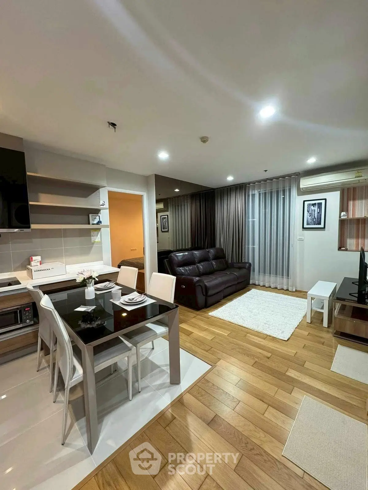 Modern open-plan living room with sleek kitchen and cozy seating area.