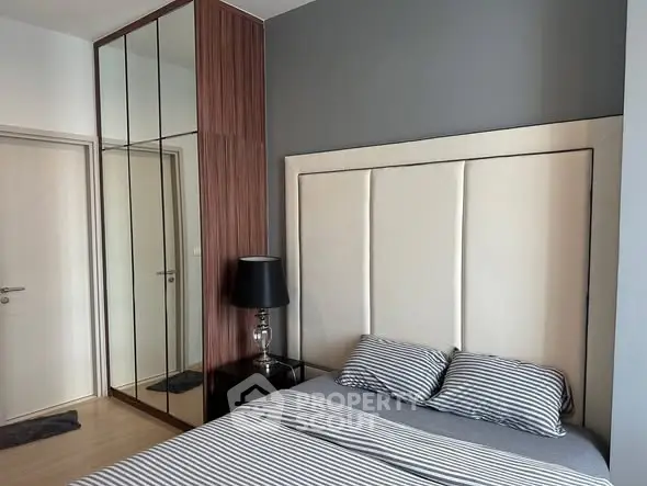 Modern bedroom with stylish decor and mirrored wardrobe