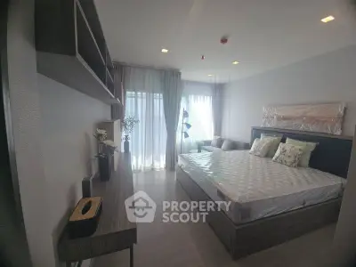 Modern bedroom with stylish decor and natural light, featuring a cozy bed and elegant furnishings.