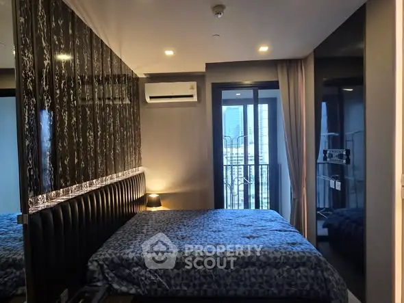 Modern bedroom with stylish decor and balcony view in urban apartment.