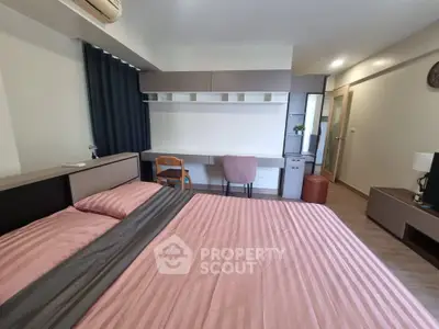 Modern bedroom with stylish furniture and workspace, perfect for urban living.