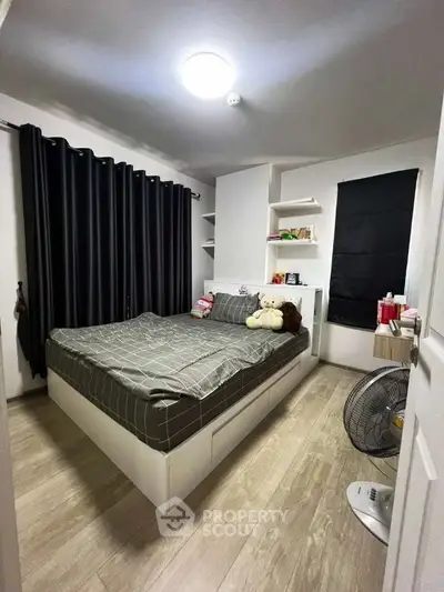 Cozy bedroom with modern decor and ample natural light, featuring stylish furnishings and elegant flooring.