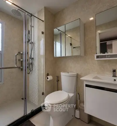 Modern bathroom with glass shower and sleek fixtures in luxury apartment.