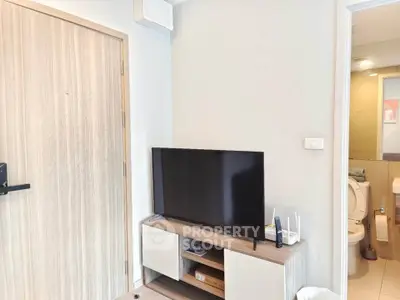 Modern apartment interior with TV and bathroom view