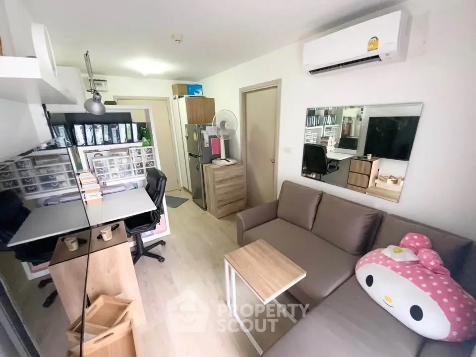 Charming compact living room with modern decor and efficient workspace setup, perfect for urban living.