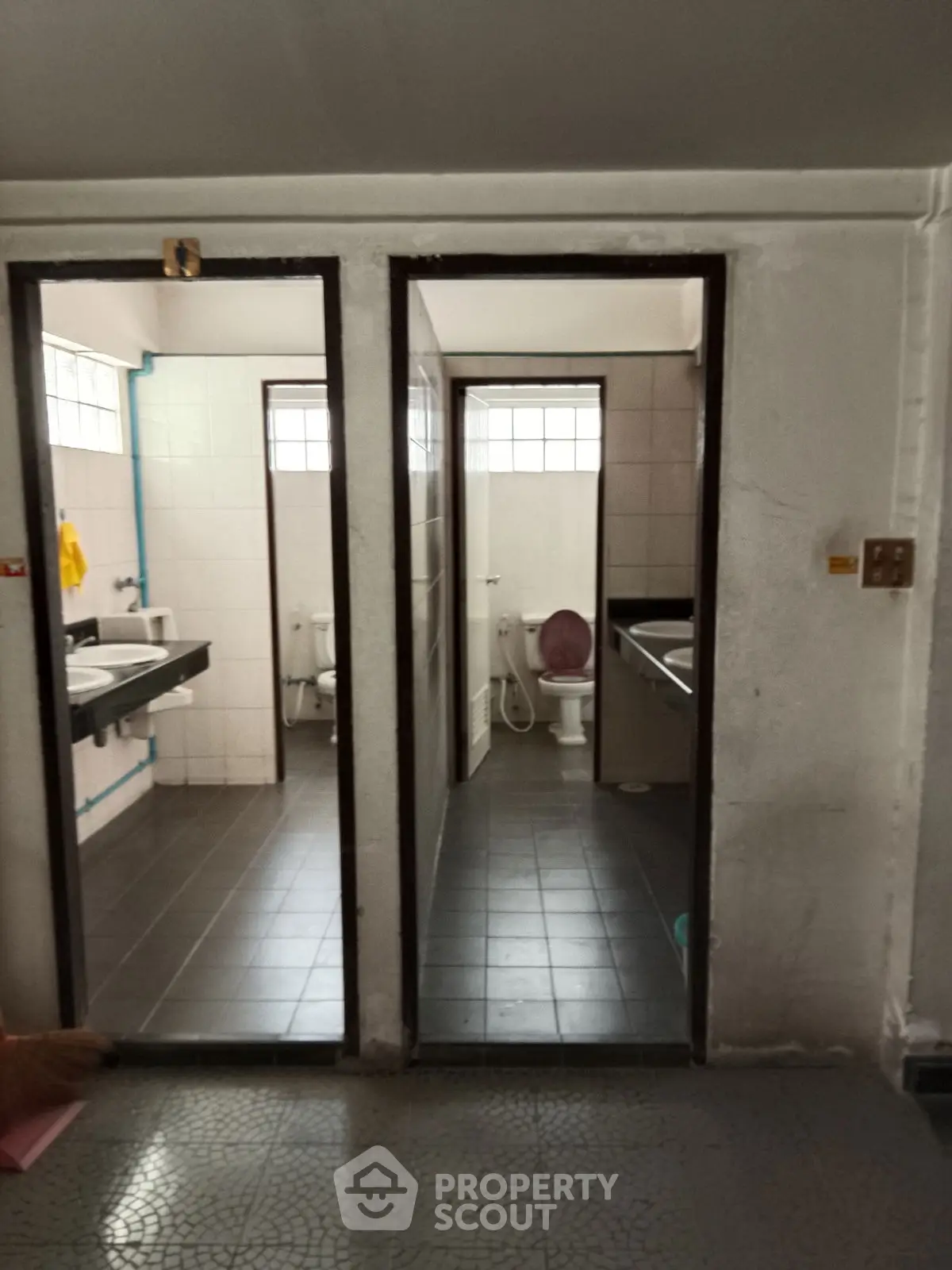 Dual bathroom setup with tiled flooring and modern fixtures, ideal for shared spaces.