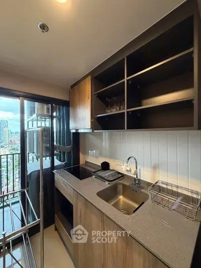 Modern kitchen with sleek cabinetry and city view from balcony, perfect for urban living.