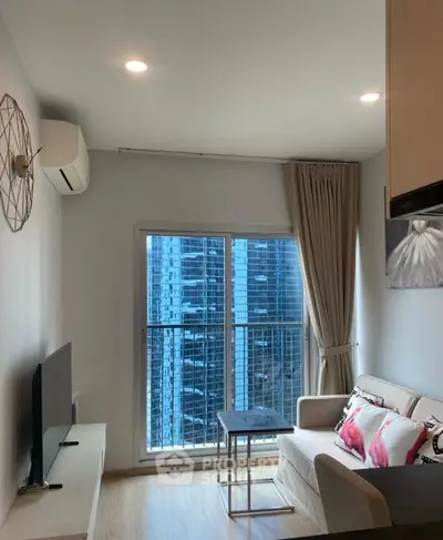 Modern living room with city view, featuring stylish decor and natural light.