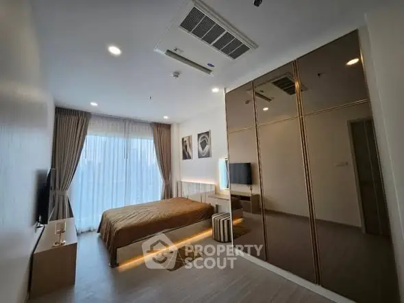 Modern bedroom with sleek design, large mirrored wardrobe, and ambient lighting.