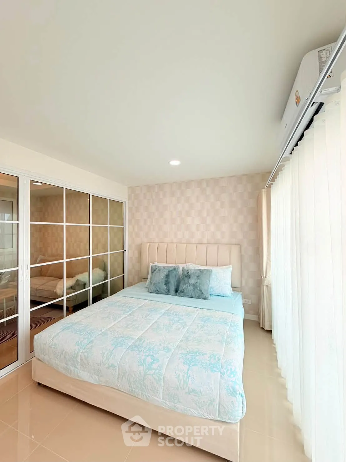 Bright and cozy bedroom with elegant decor and large mirrored closet doors.