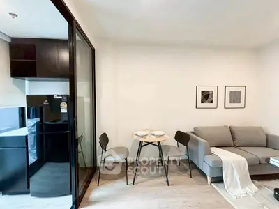 Modern living room with cozy sofa and compact dining area next to sleek kitchen.