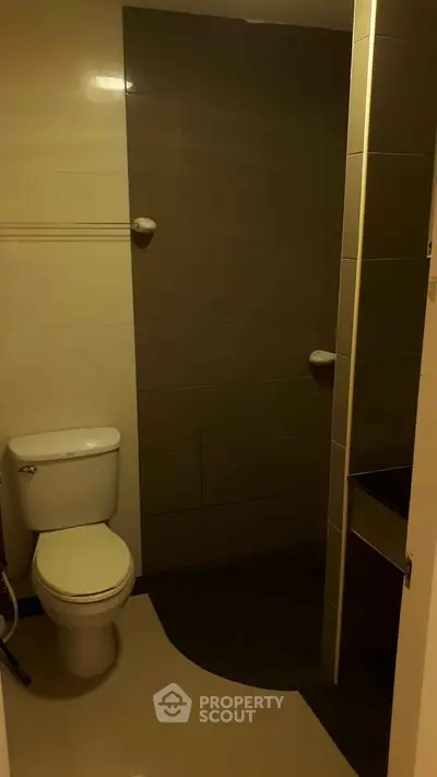Compact bathroom with modern fixtures and neutral tiles